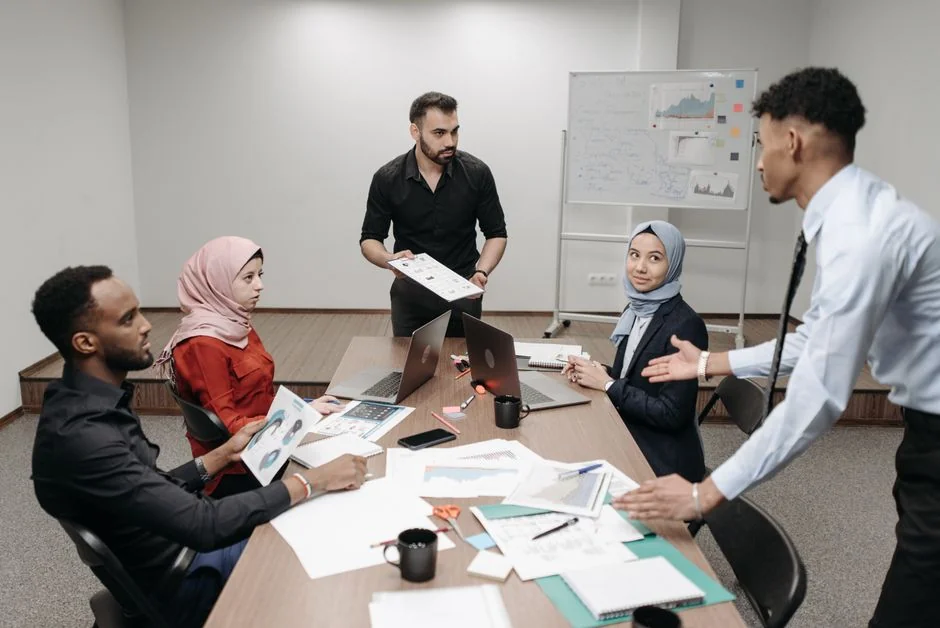 Overhead view of a team discussing digital marketing strategies with laptops and charts.